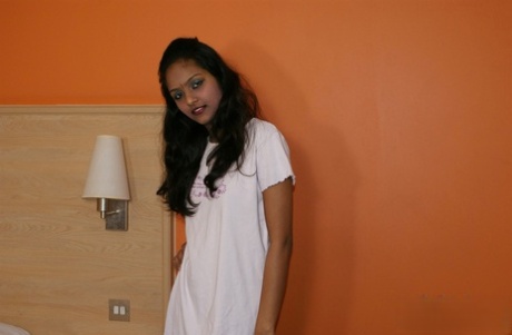 Indian female Divya lifts up a white dress to expose her vagina
