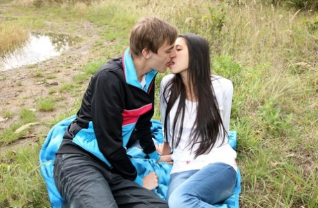 Horny couple find sexual relief during intercourse on blanket in a field