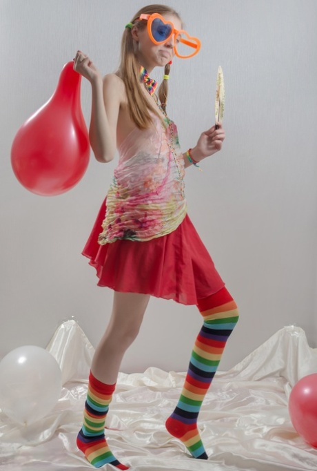 Skinny teen girl in pigtails and multi-colored socks takes off her clothes