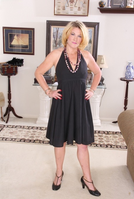 Hot mature woman Kelsey Johnson cups her tits before spreading her slit