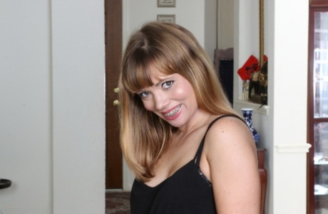 American housewife teasingly strips to black stockings in her living room