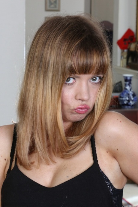 American housewife teasingly strips to black stockings in her living room
