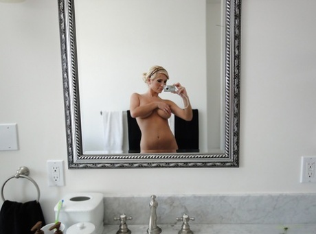 Beautiful blonde Tasha Reign taking selfies in mirror while removing pretties