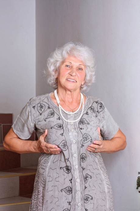 Cute granny Betty strips to her lingerie and masturbates on the stairs