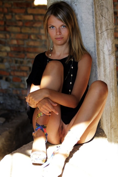 Sweet skinny teen in a black dress Anuta B undresses and poses naked outdoors
