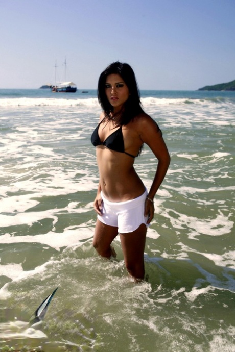 Dark-haired MILF Sunny Leone displaying her hot naked body on the beach