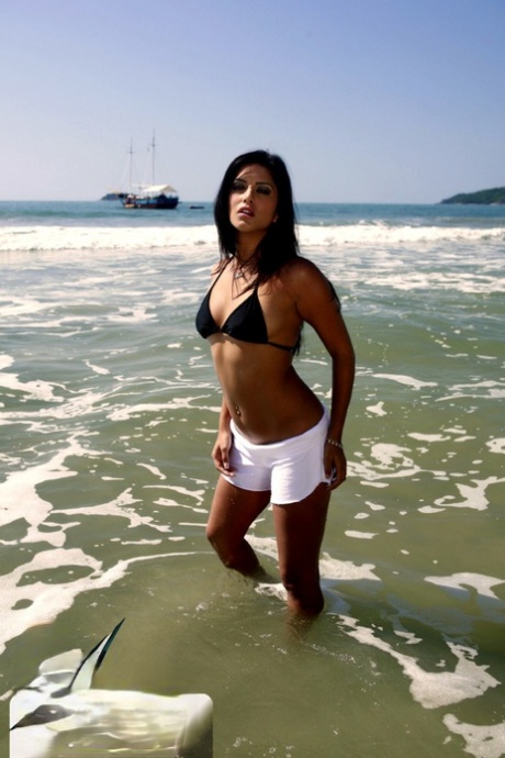 Dark-haired MILF Sunny Leone displaying her hot naked body on the beach
