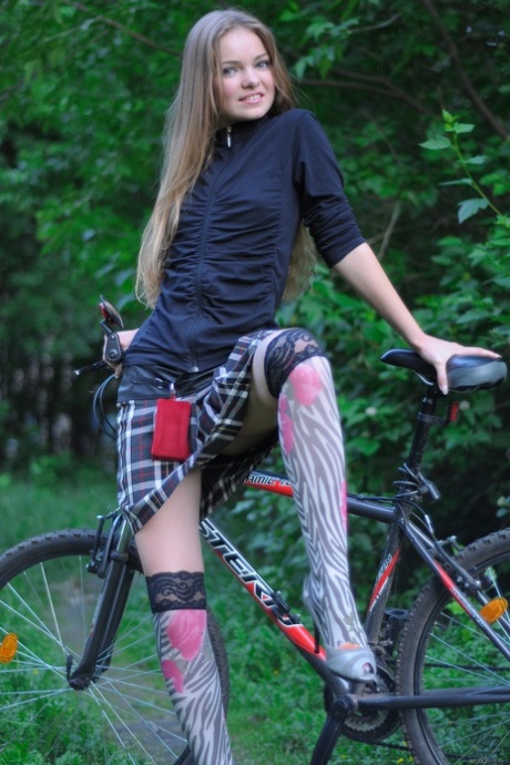 Gorgeous teen babe Bridgit A riding her bicycle pantyless in nature