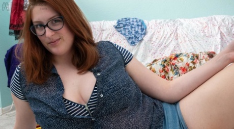Chubby redheaded geek Breanna reveals her huge breasts and toys her bush