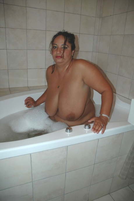 Fat amateur woman Irene teases with her huge melons as she takes a bubble bath