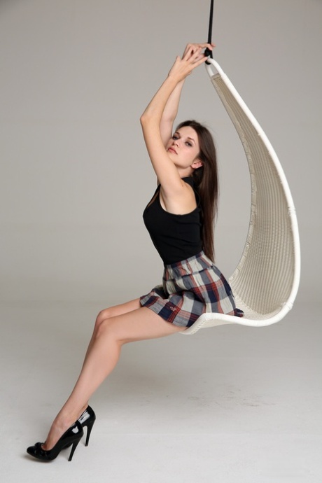 Teen with a small bosom Serena undresses and poses on an indoor swing
