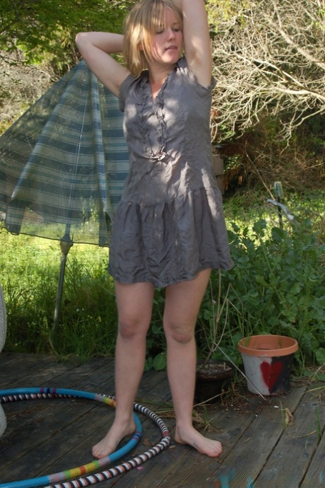 Blonde stunner Ana displays her unshaved armpits and hairy pussy outdoors