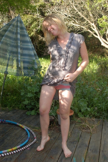 Blonde stunner Ana displays her unshaved armpits and hairy pussy outdoors