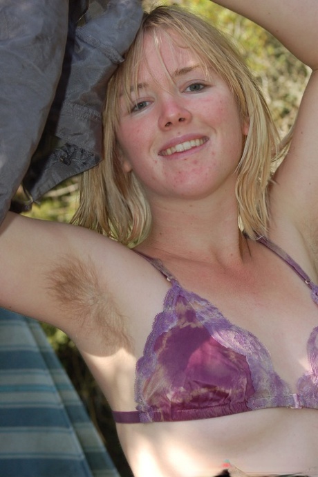Blonde stunner Ana displays her unshaved armpits and hairy pussy outdoors