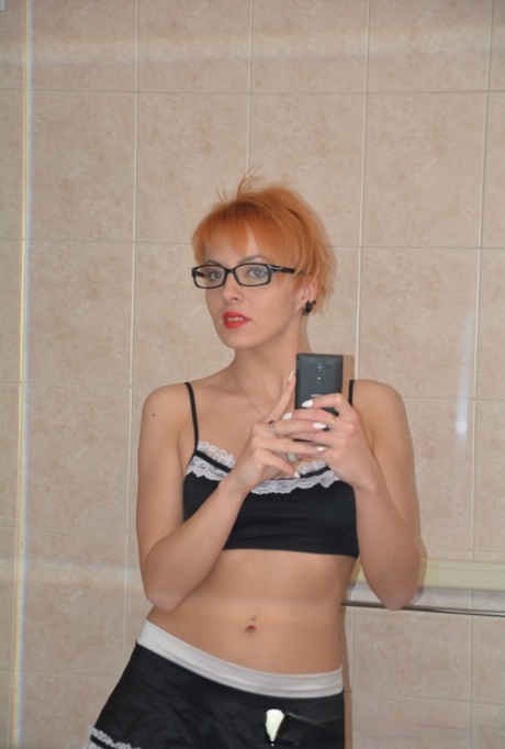 Redheaded MILF strips her maid uniform and poses naked in the bathtub