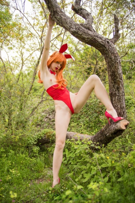 Redheaded babe with bunny ears Milena Angel spreads her pussy in the forest