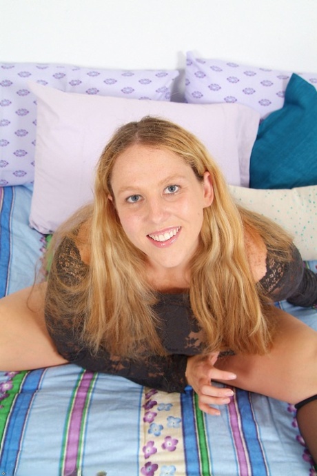 Chubby blonde Fiona spreads her trimmed pussy while stripping on her bed