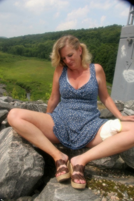 Kinky blonde mature Raylynn shows her ass and spreads her twat outdoors