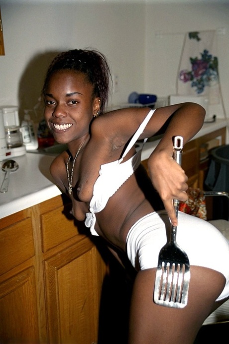Petite black babe Jezebel takes a piss during a sexy striptease