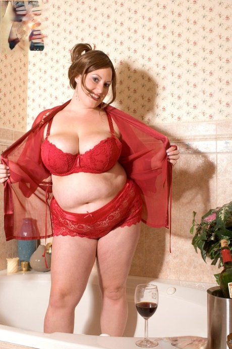 Fatty mature brunette Nikki Cars washing her large natural tits in the bathtub
